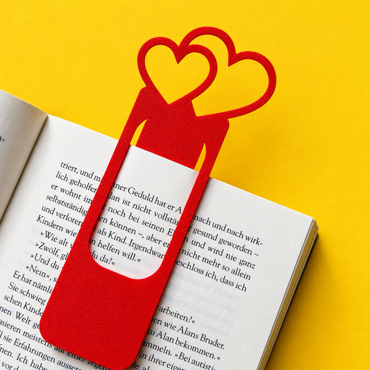 Red bookmark with two heart outlines marking the page of an open book
