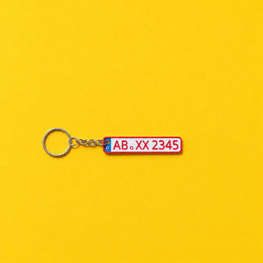 Miniature license plate keychain with red lettering and red border on a yellow background