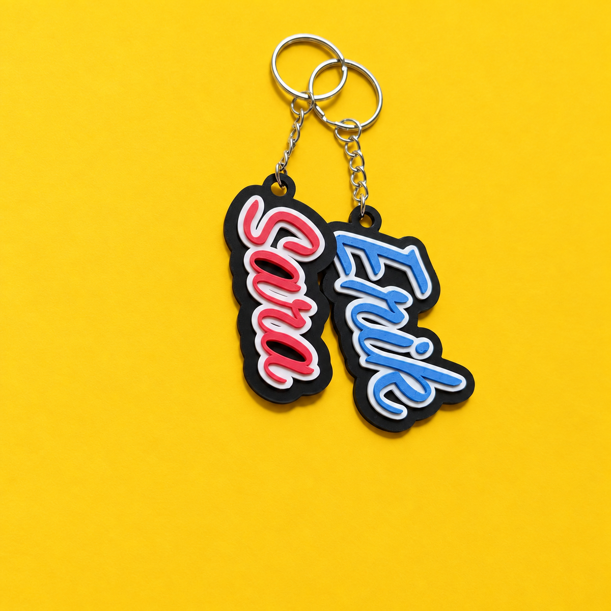 Sara and Erik personalized name keychains shown vertically with silver rings