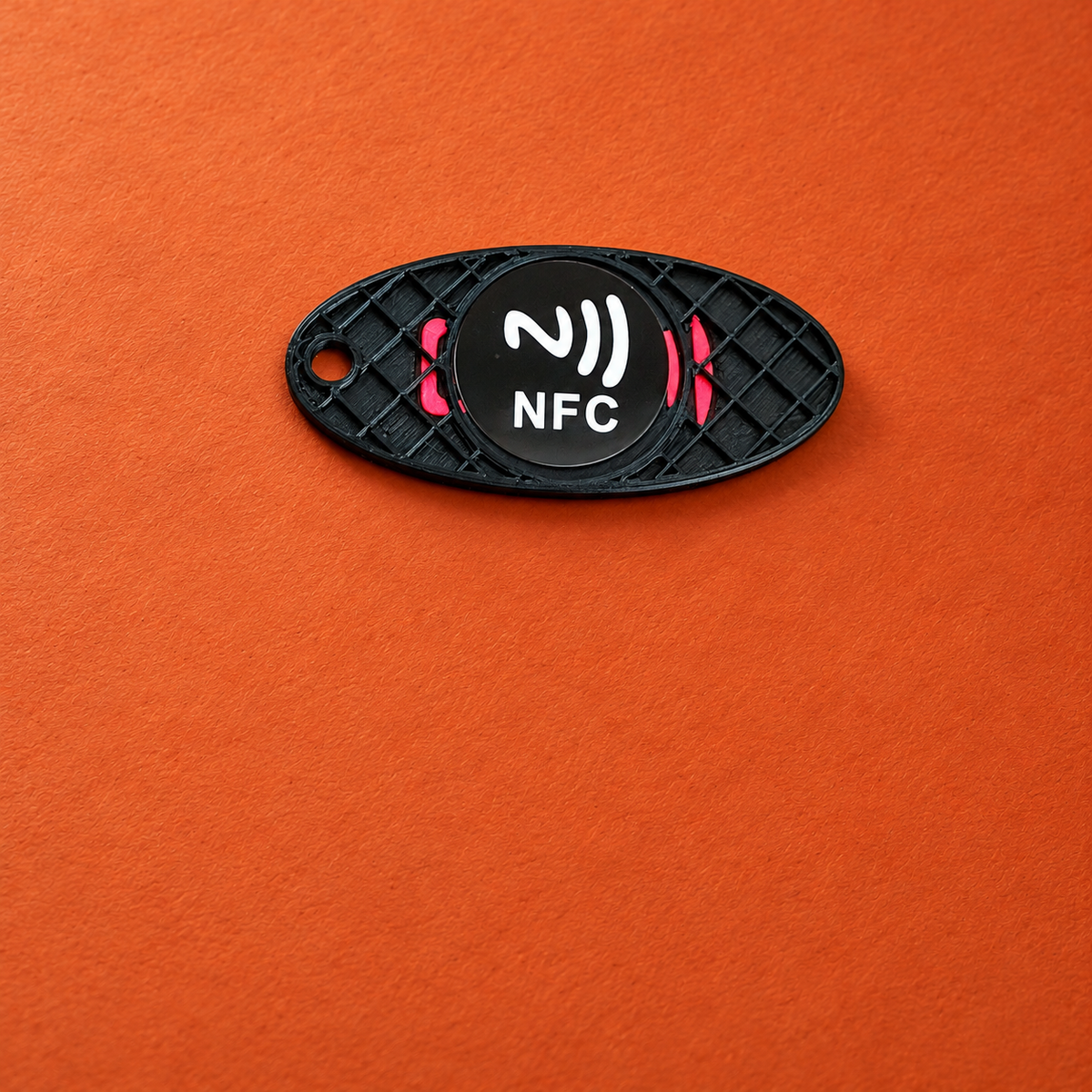 Detail des eingebauten NFC-Chips im geöffneten Schlüsselanhänger auf Terrakotta