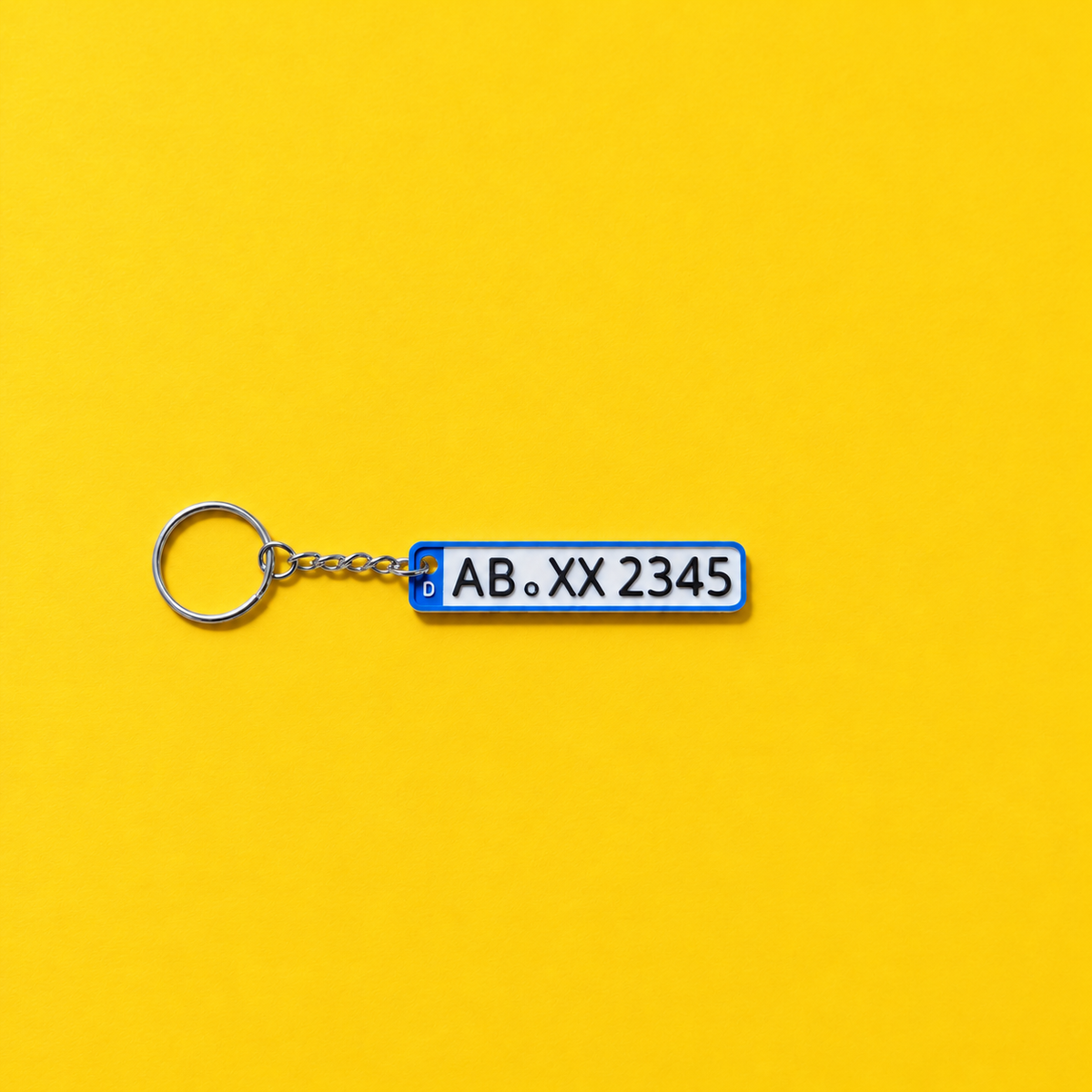 Miniature license plate keychain with black lettering and blue border on a yellow background