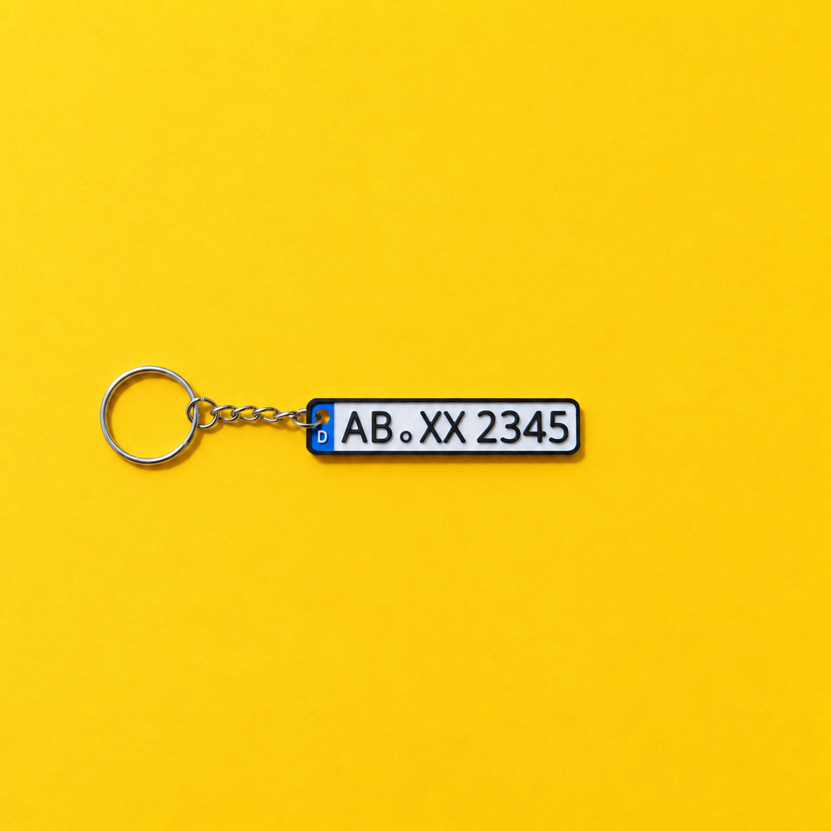 Miniature license plate keychain with black lettering and black border on a yellow background