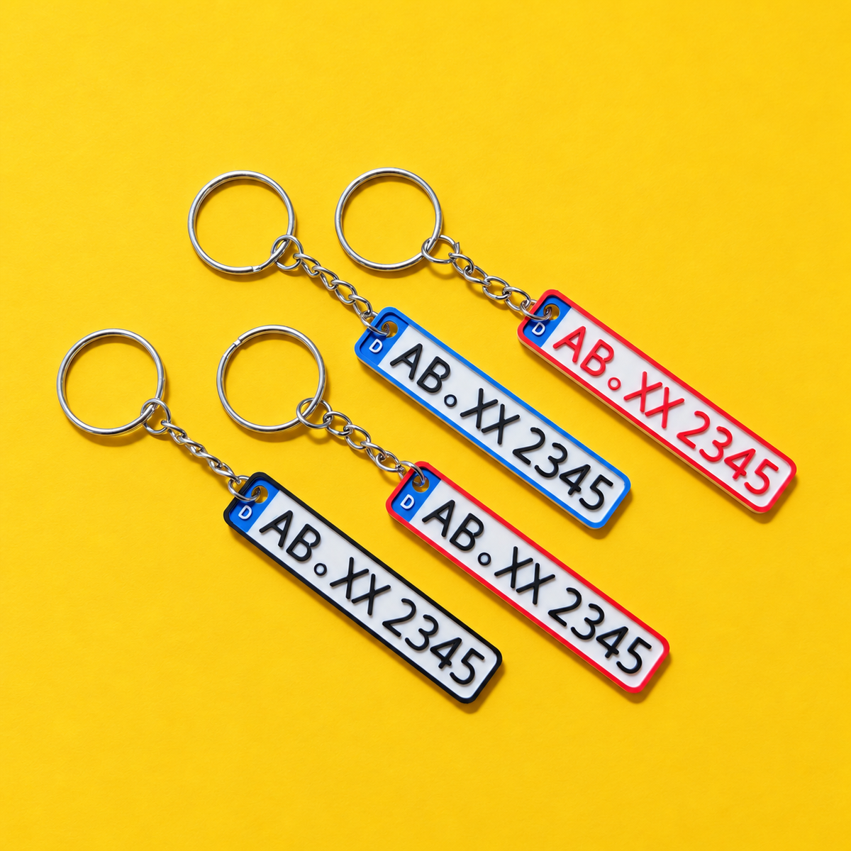 Four personalized miniature license plate keychains with red, blue and black borders