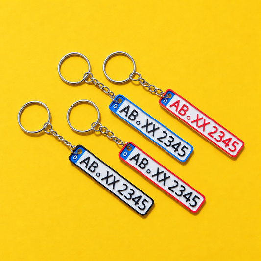 Four personalized miniature license plate keychains with red, blue and black borders