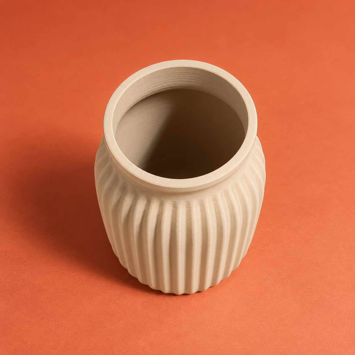 Top view of the empty beige ribbed 3D printed vase showing its circular opening and interior